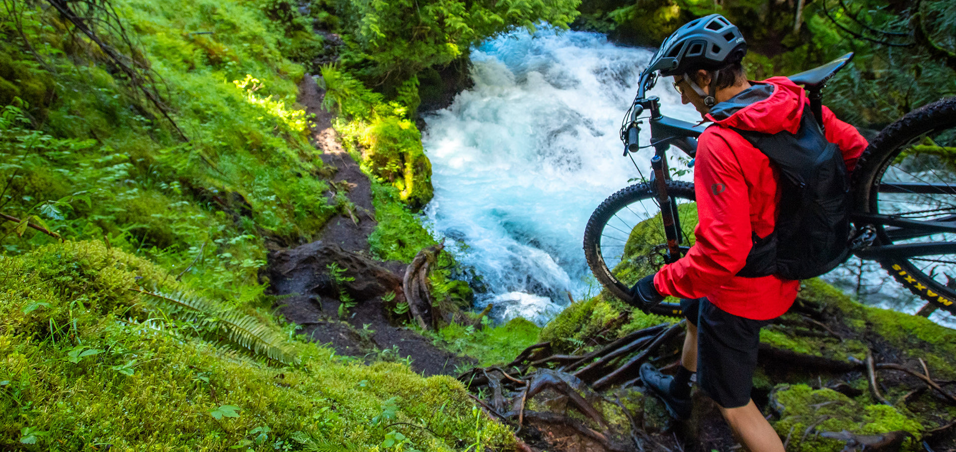 Mountain Biker Carrying Bike Down an Extremely Technical Trail